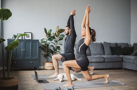 Young couple at home practicing yoga.